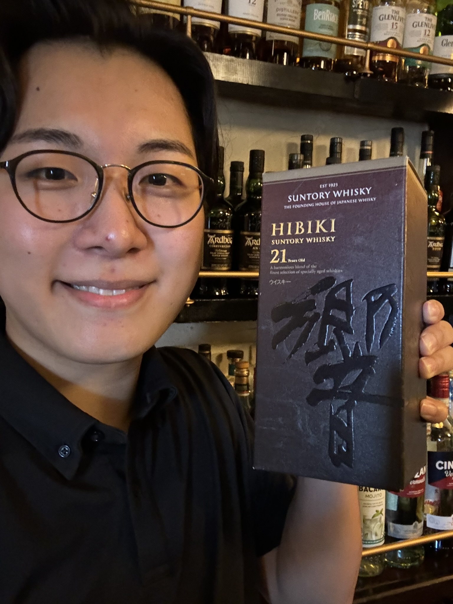 Hibiki Shimizu — holding HIBIKI 21 whisky at a whisky bar
